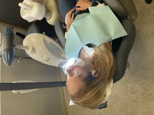 Patient laying down in a chair while having their teeth whitened